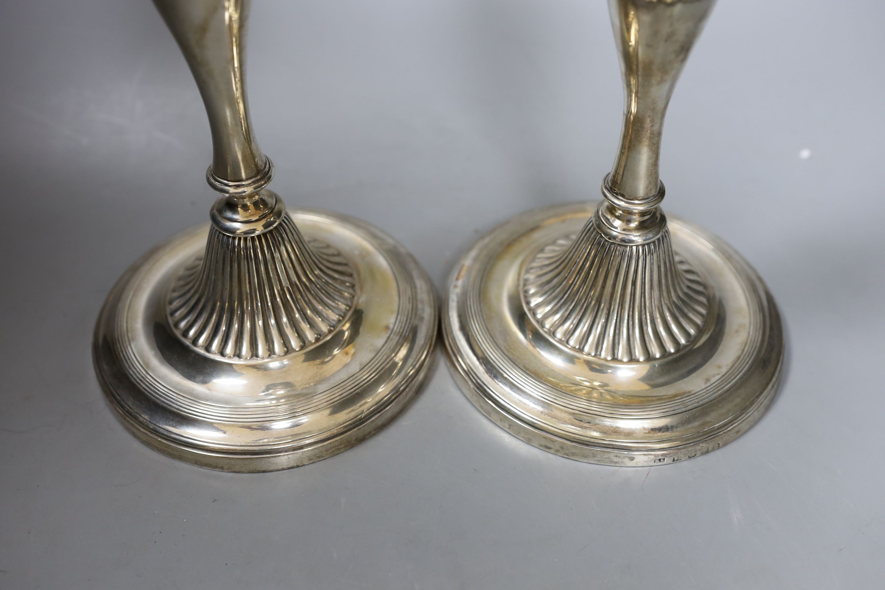 A pair of George III silver candlesticks, with waisted fluted stems, R.S. Sheffield, 1793 & 1796, 22.9cm, weighted (a.f.).